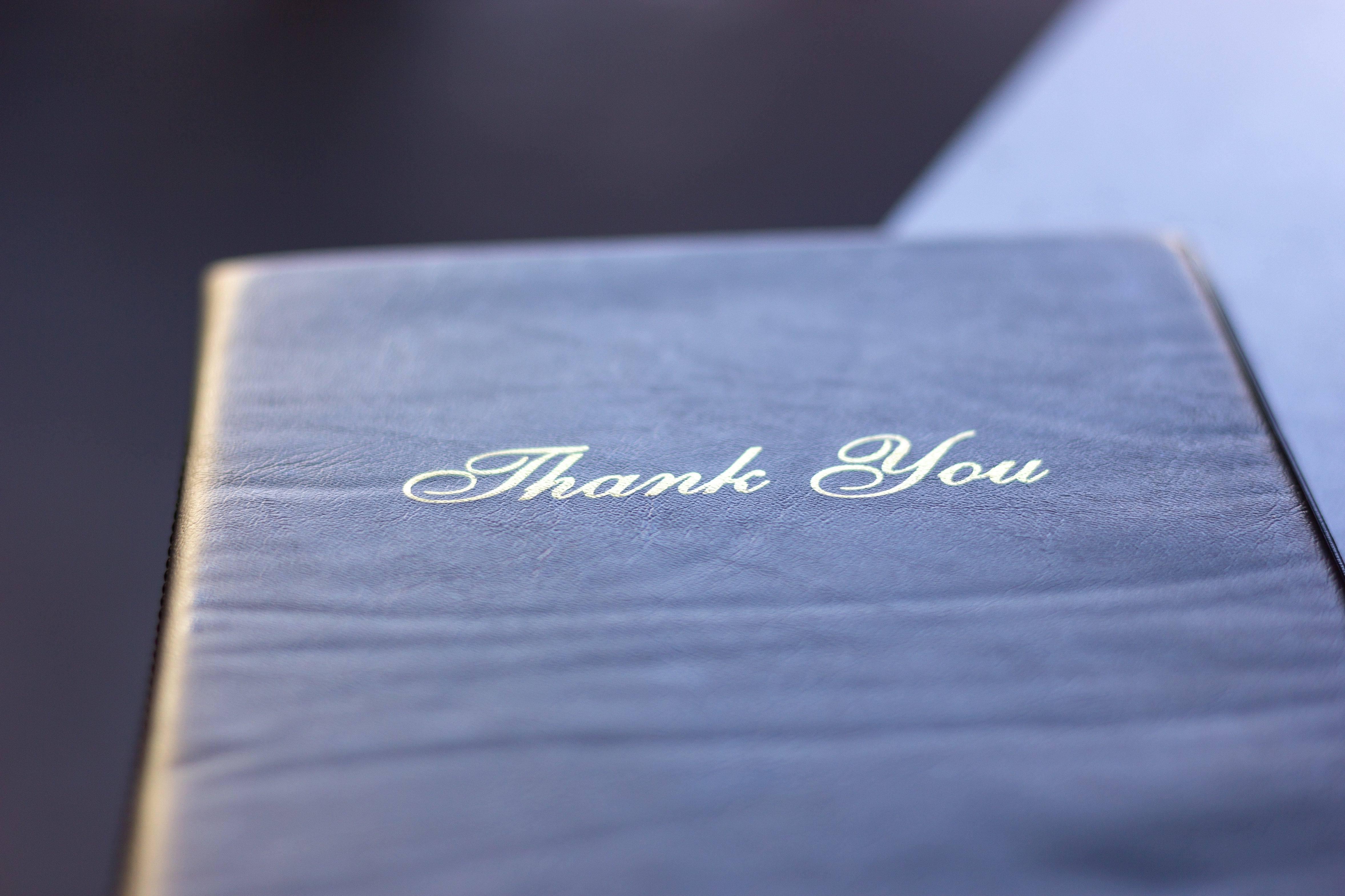 Close-up of a paper with "Thank You" written connected the screen successful elegant script