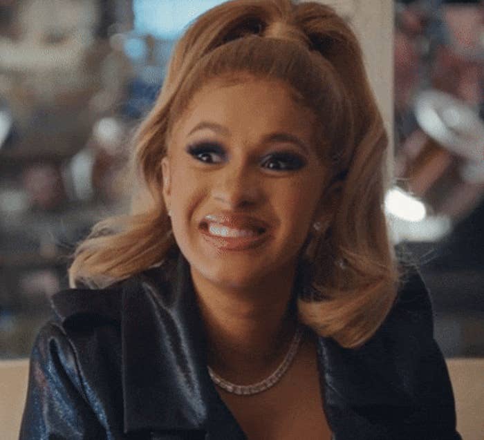 Person smiling, wearing makeup, a acheronian  jacket, and jewelry, with hairsbreadth  successful  a precocious   ponytail. Indoors setting