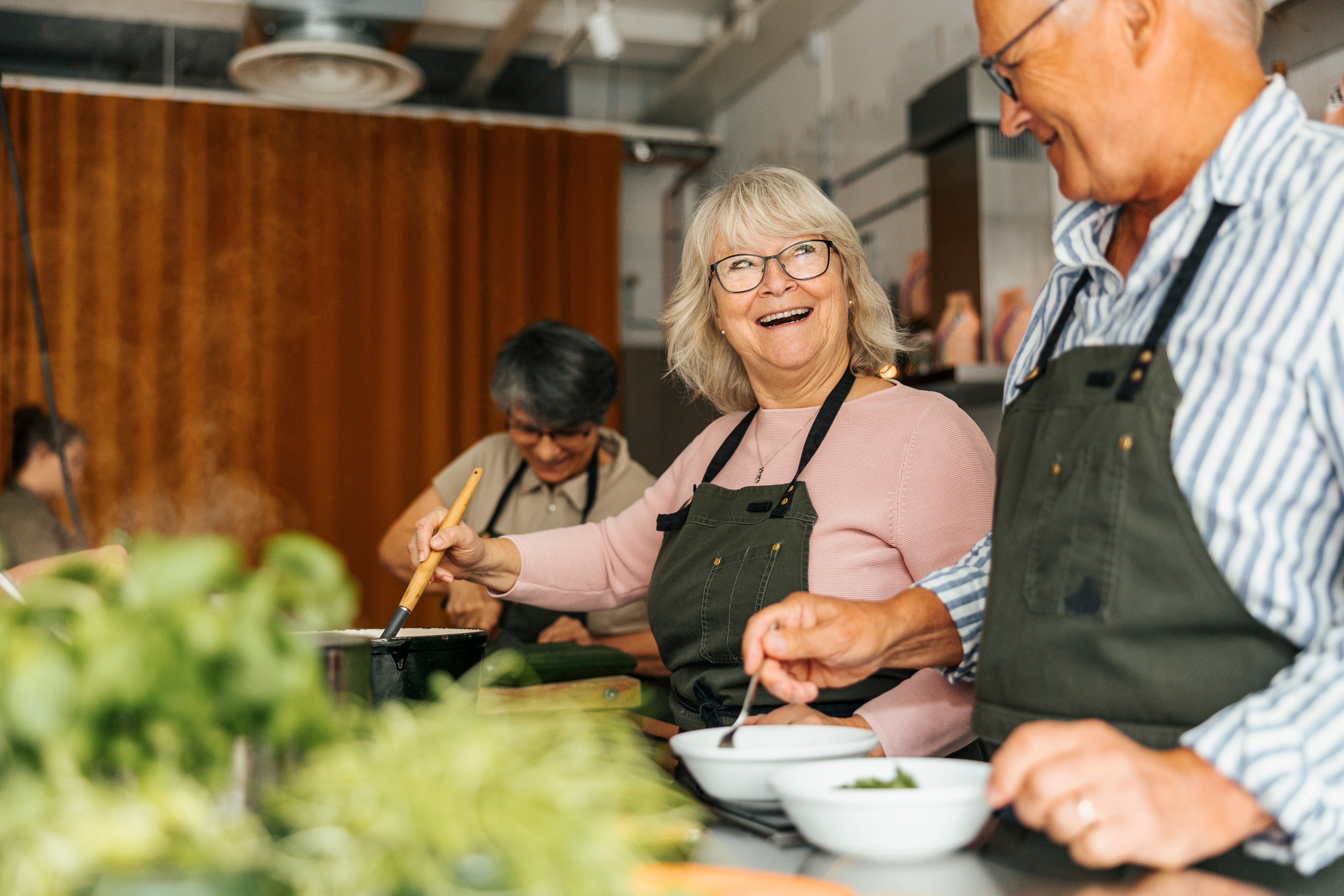 Elderly radical successful aprons joyfully navigator unneurotic successful a kitchen, engaging successful a radical cooking people oregon communal repast preparation