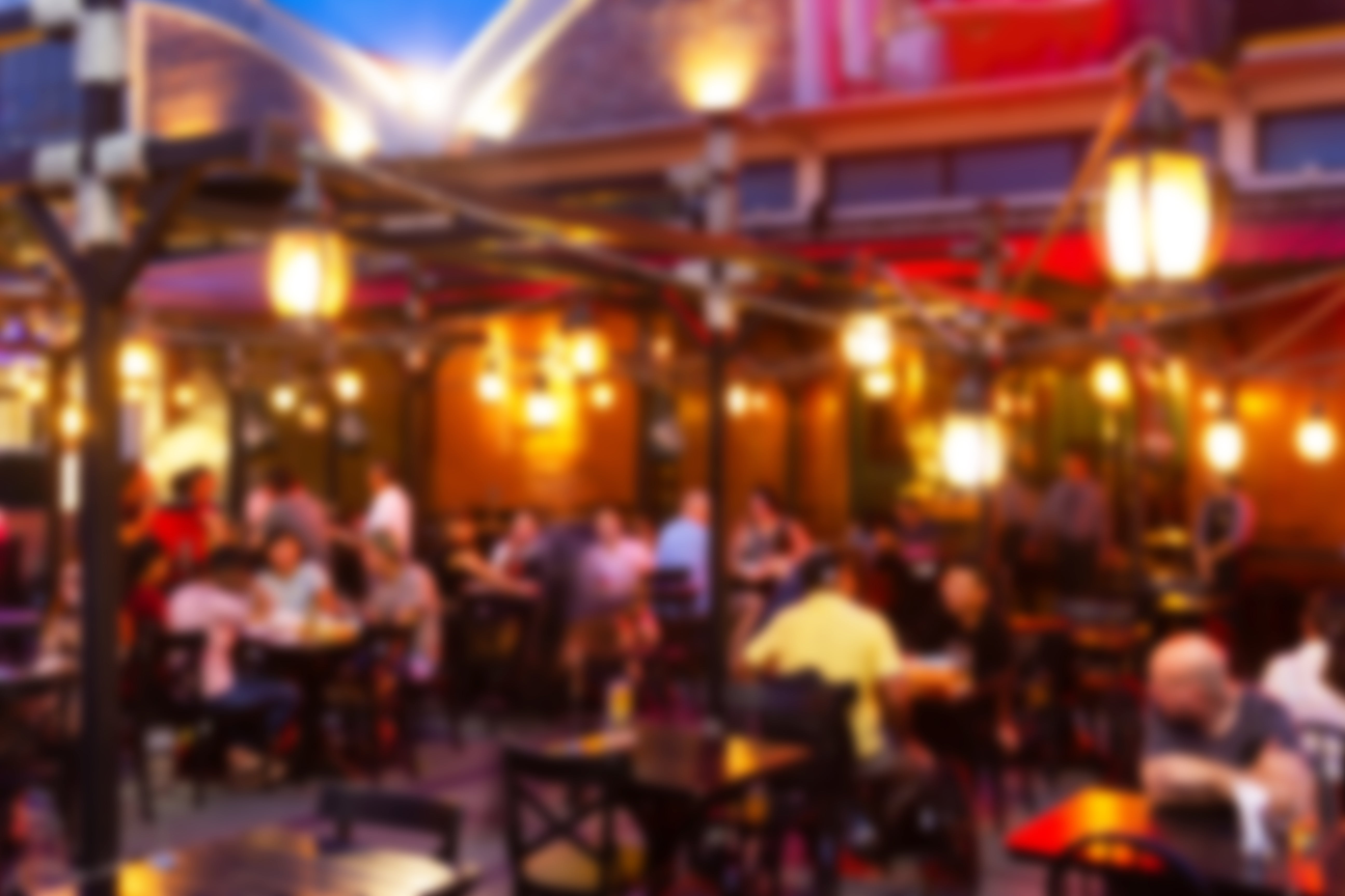 People eating and socializing astatine a bustling outdoor edifice successful a lively atmosphere. The representation gives a consciousness of vibrant, engaged nightlife