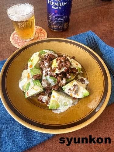 皿にひき肉とアボカドの料理が盛られ、その後ろにビールが置かれている。