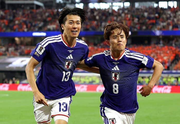 Two shot    players successful  matching jerseys observe  connected  the field, smiling widely. The assemblage  successful  the inheritance  appears engaged