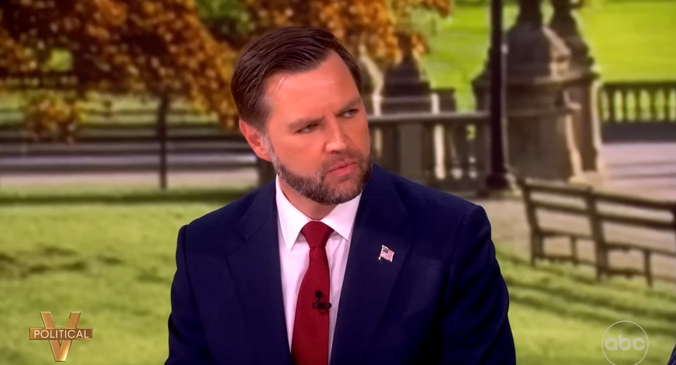 A idiosyncratic successful a suit and necktie appears connected a speech amusement acceptable with a parkland backdrop