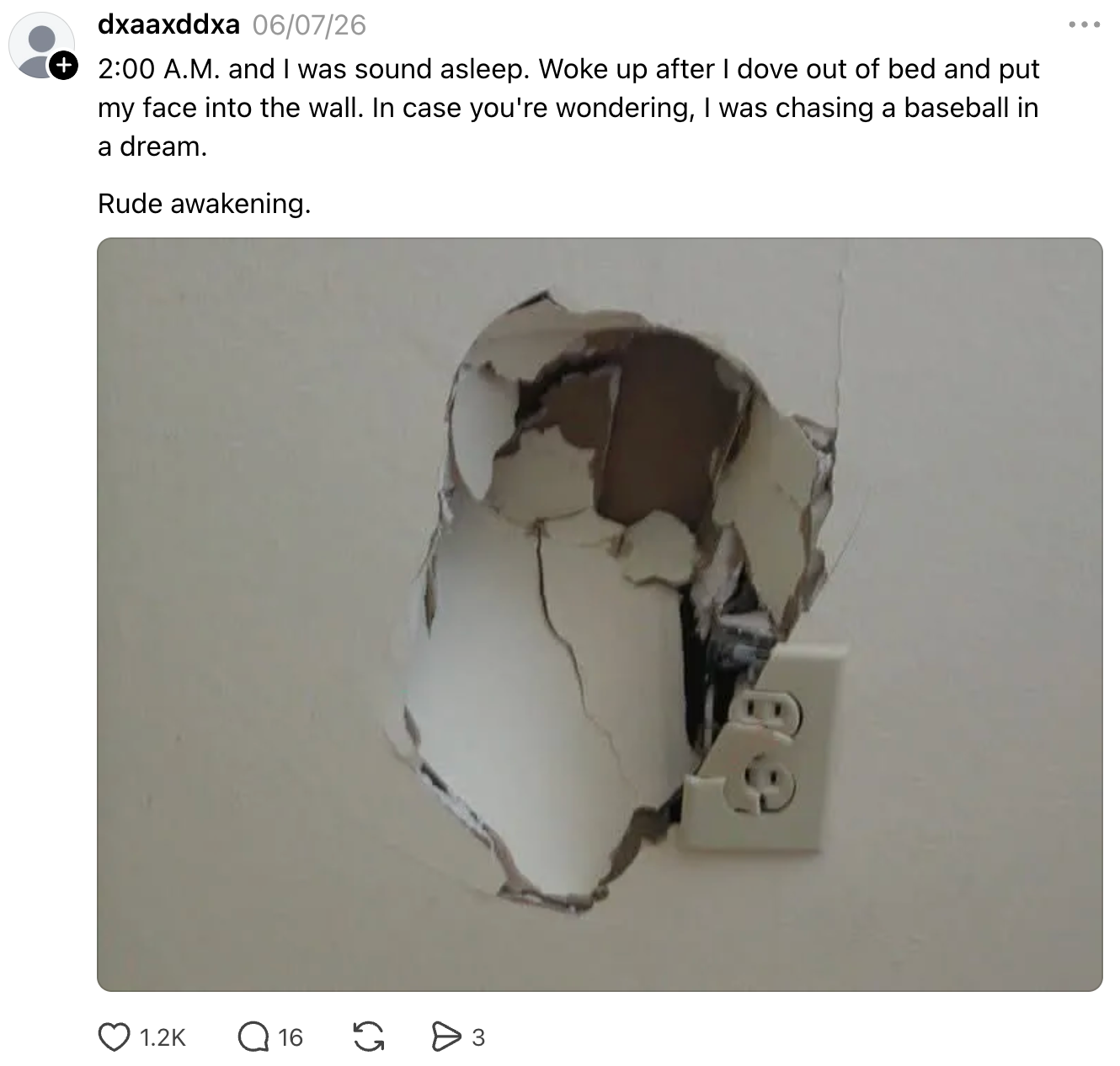 Wall with a large hole above an electrical outlet, described as the result of someone diving out of bed while dreaming of chasing a baseball