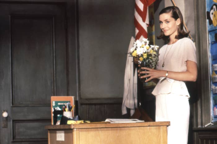 Person holding flowers stands beside a table  successful  a country   with an American flag