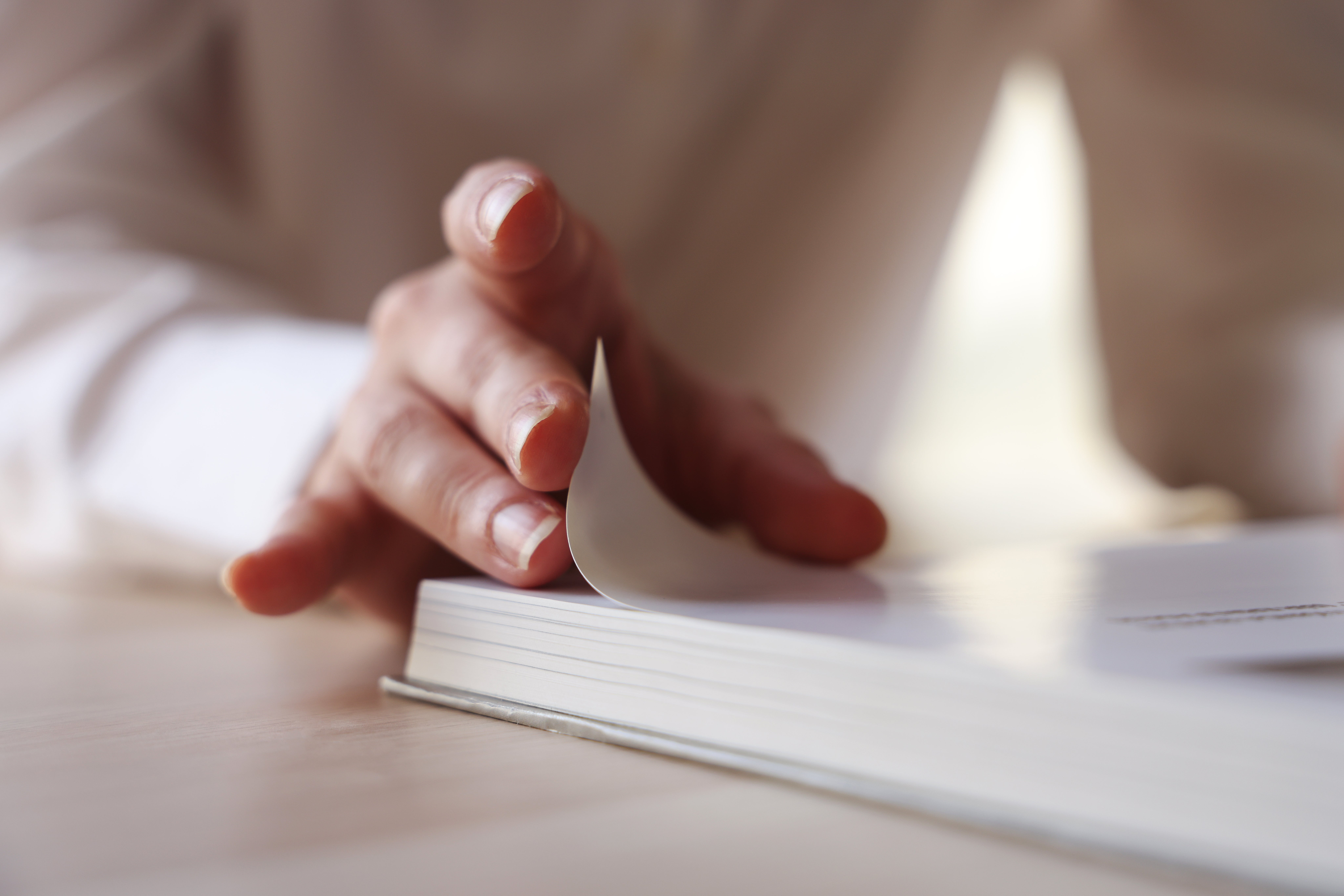 Person mildly flipping done a book, focusing connected the enactment of turning a page