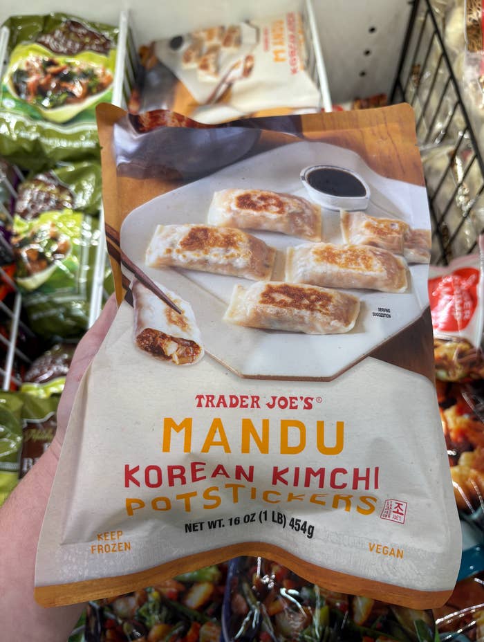 Trader Joe's Korean Kimchi Mandu Potstickers package held in hand, displayed in a grocery freezer