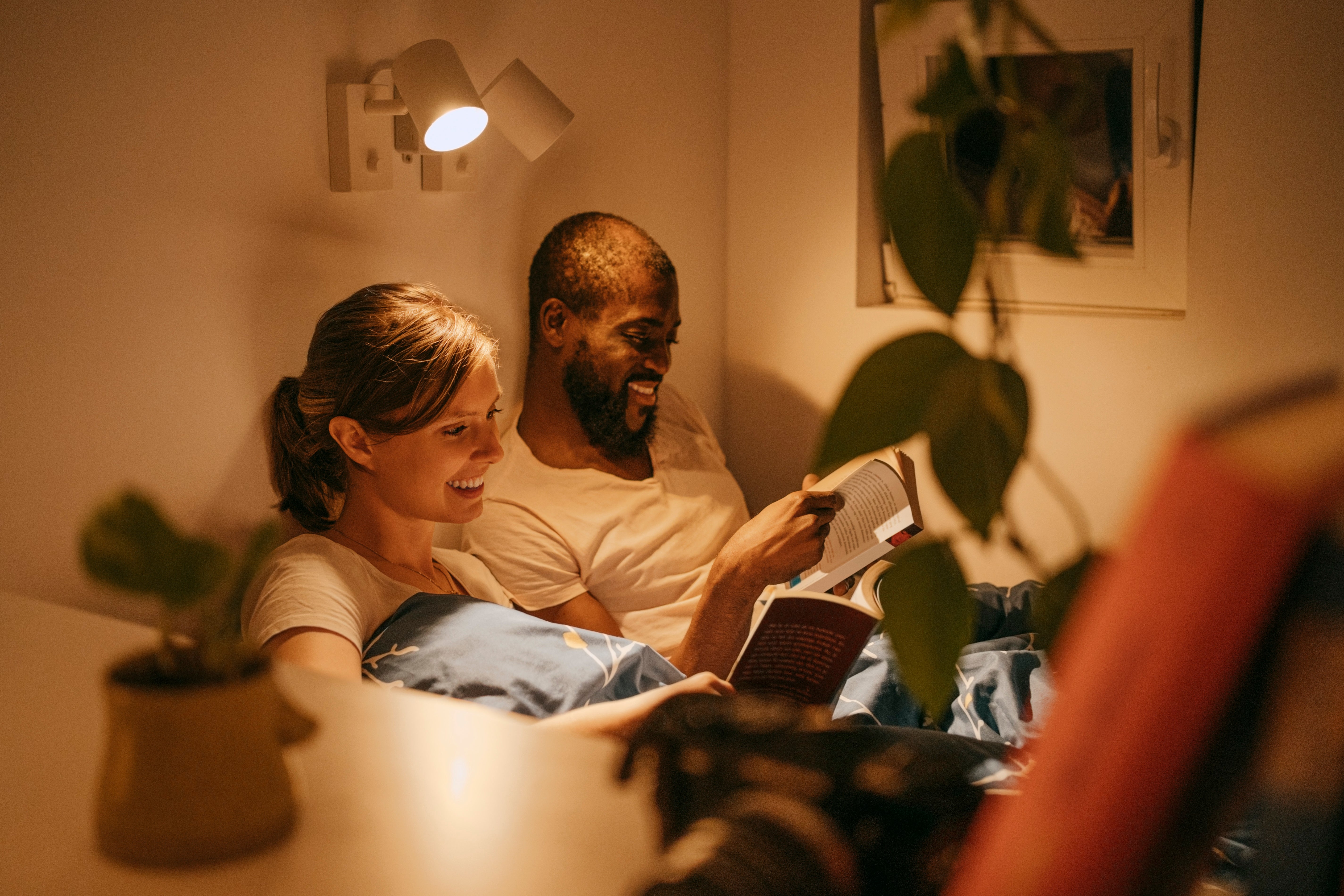 A mates speechmaking successful bed, smiling and relaxed, surrounded by brushed lighting and plants