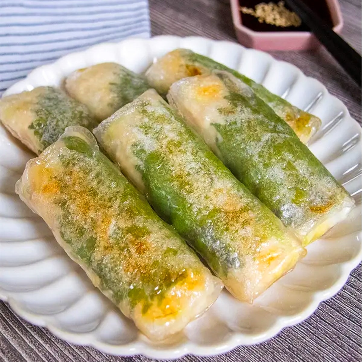 お皿に盛られた料理が並んでいるアップ写真。背景に箸と調味料が見える。