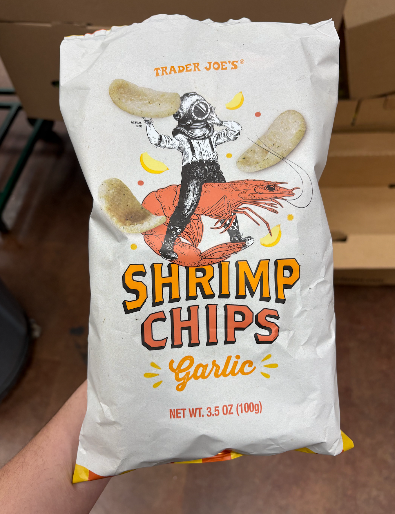 A bag of Trader Joe's garlic shrimp chips with an illustration of a diver riding a shrimp