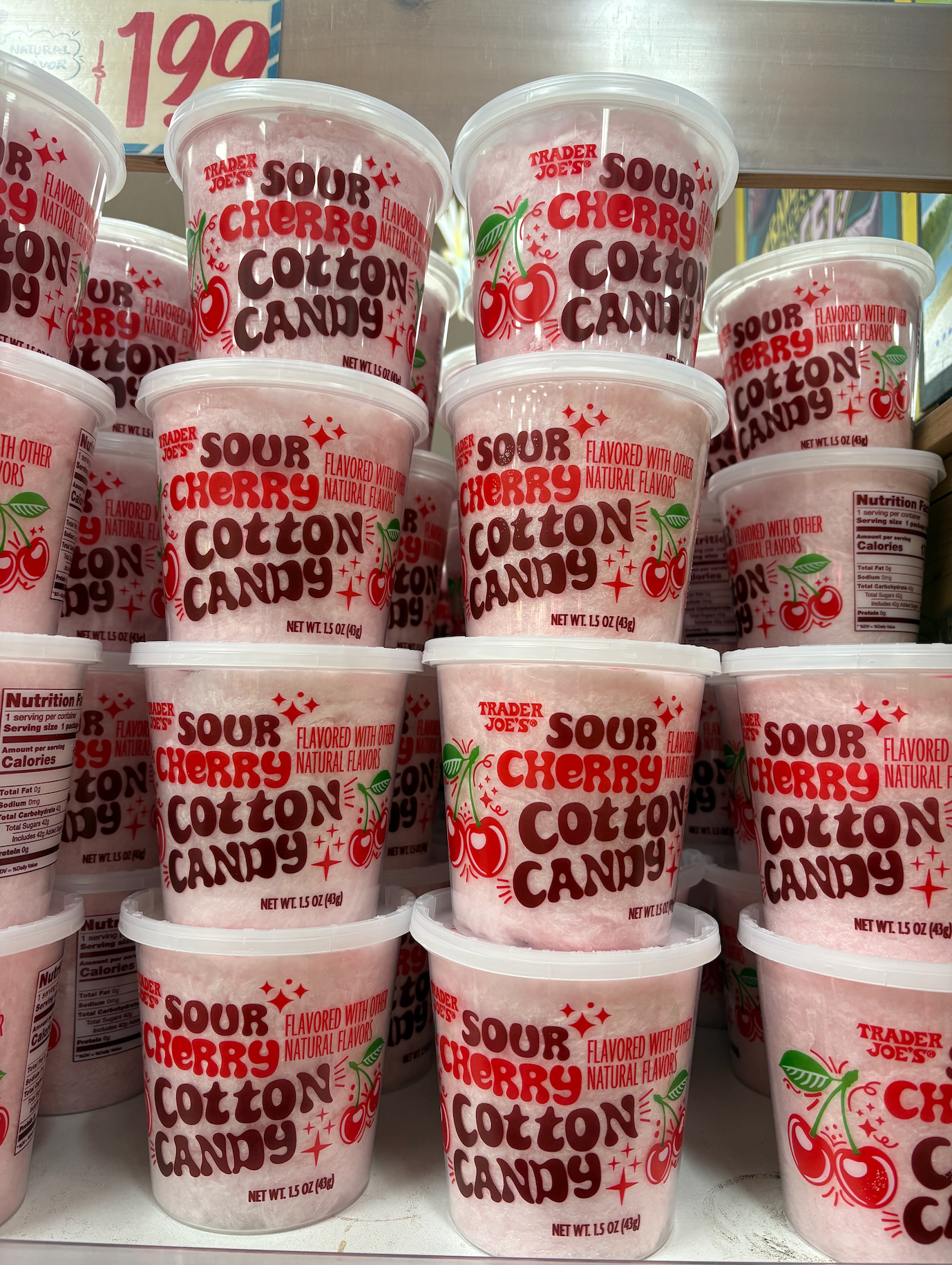 Tubs of Trader Joe's Sour Cherry Cotton Candy stacked on a store shelf