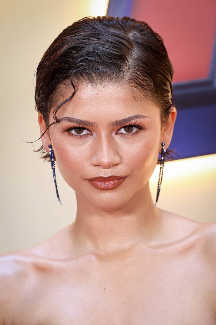 Person with wavy hairsbreadth  and driblet  earrings, wearing off-shoulder attire astatine  a ceremonial  event
