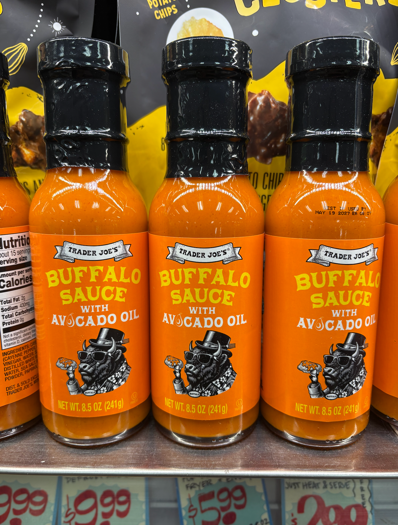Three bottles of Trader Joe's Buffalo Sauce with Avocado Oil are displayed on a store shelf