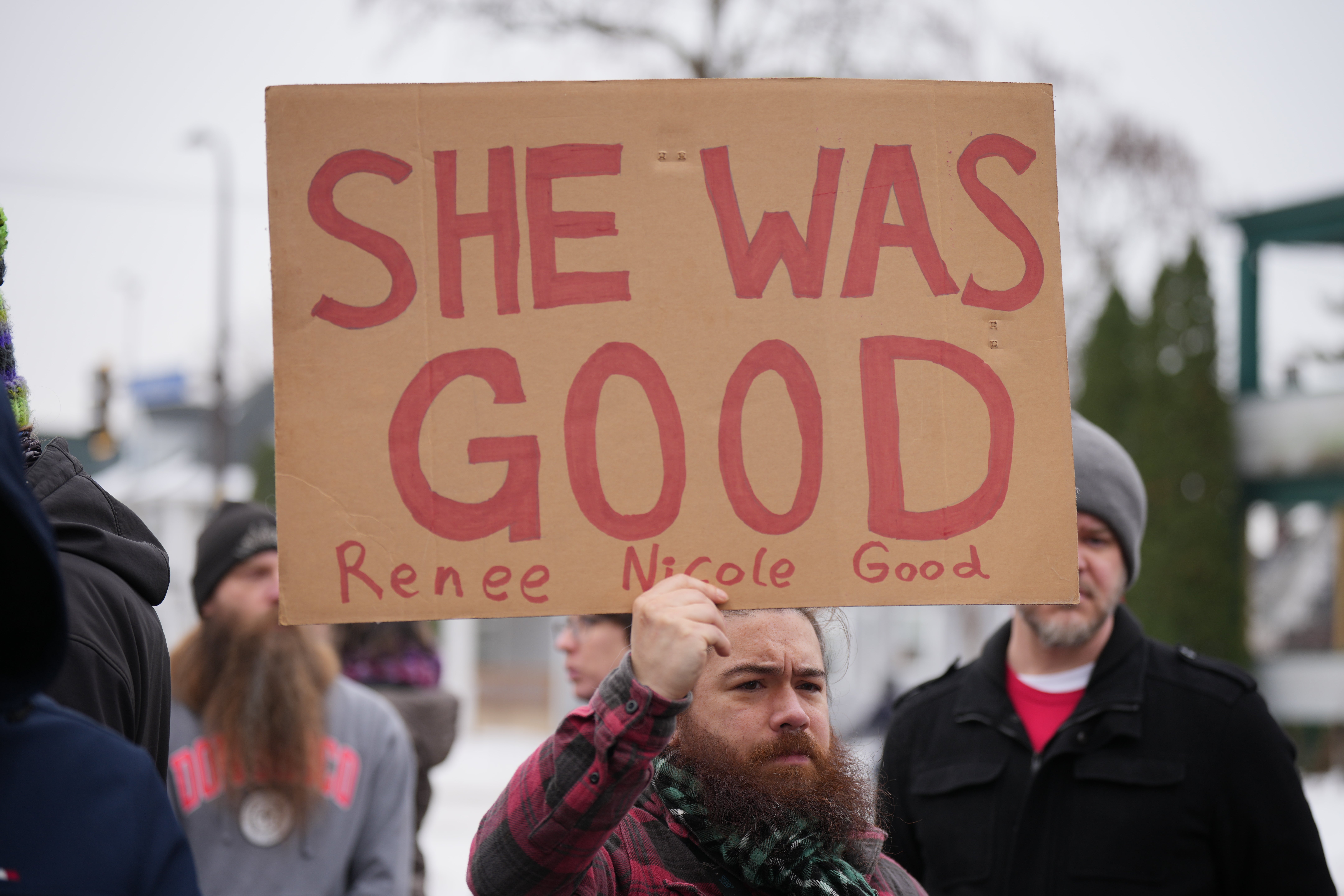 A idiosyncratic holds a motion saying "SHE WAS GOOD Renee Nicole Good" during a nationalist demonstration