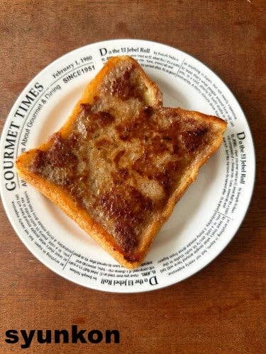 パンに甘いトッピングが乗ったトーストが、文字が書かれた白いプレートにのっている。