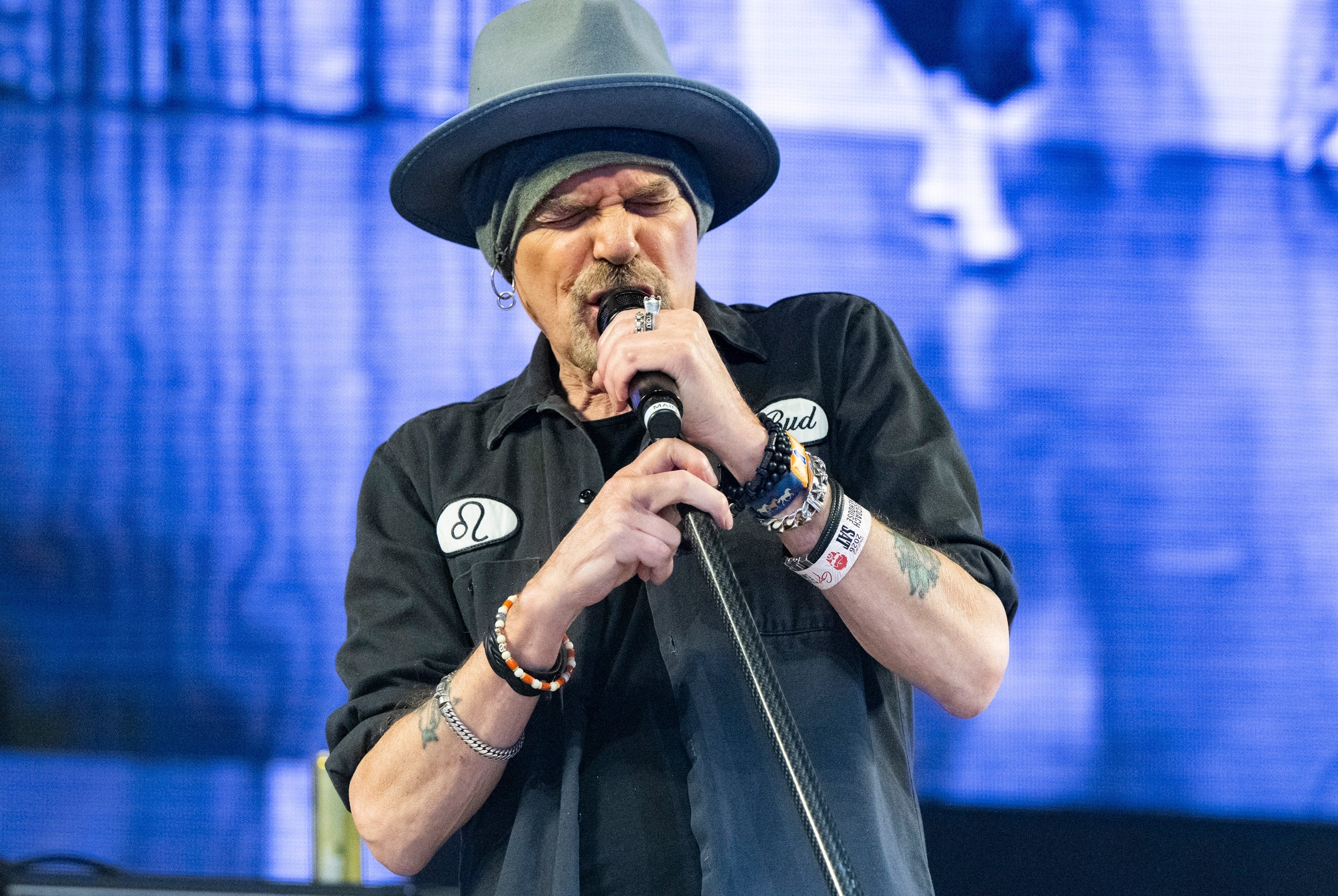 Billy Bob Thornton wearing a large hat while singing into a microphone