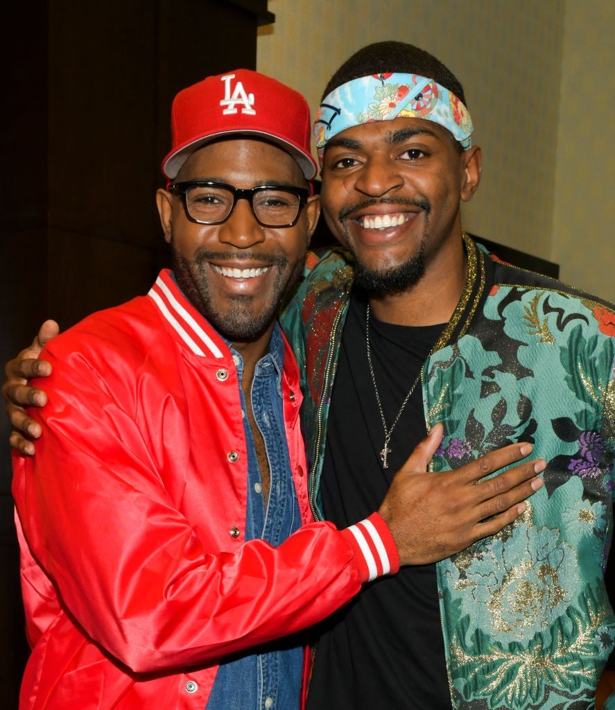 Two smiling individuals airs together. One wears a reddish overgarment and cap; the different is successful a floral overgarment with a headband