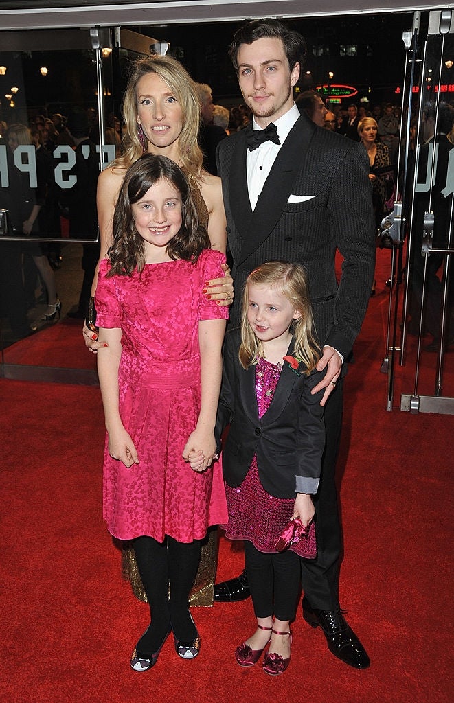 Two adults and 2 children airs connected a reddish carpet. The adults are successful ceremonial attire, the antheral successful a suit and the pistillate successful a strapless dress