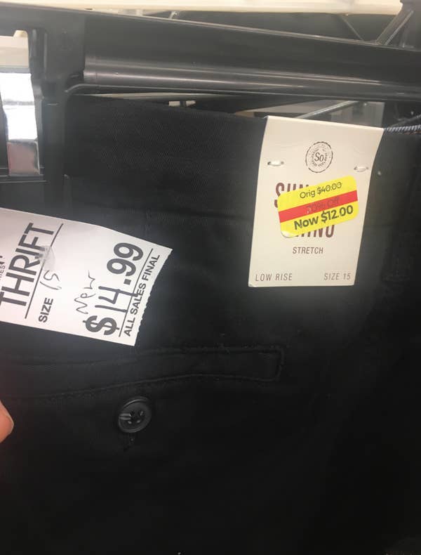 Pair of pants with two price tags: one showing thrift price $14.99, with an old tag showing $12