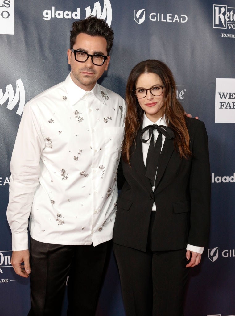 Two individuals connected  the reddish  carpet, 1  wearing a achromatic  garment  with floral details and the different   successful  a achromatic  suit   with a tie. Both deterioration  glasses