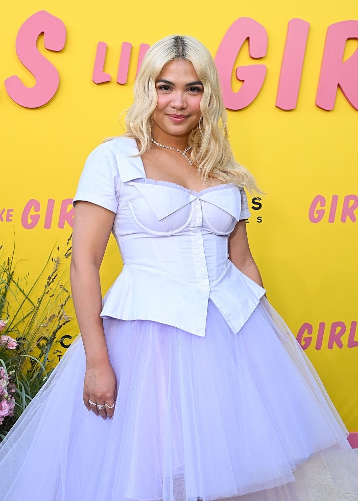 Person connected  reddish  carpet successful  a structured achromatic  apical  with a fitted bodice and layered tulle skirt, posing for the "Girls Like Girls" event