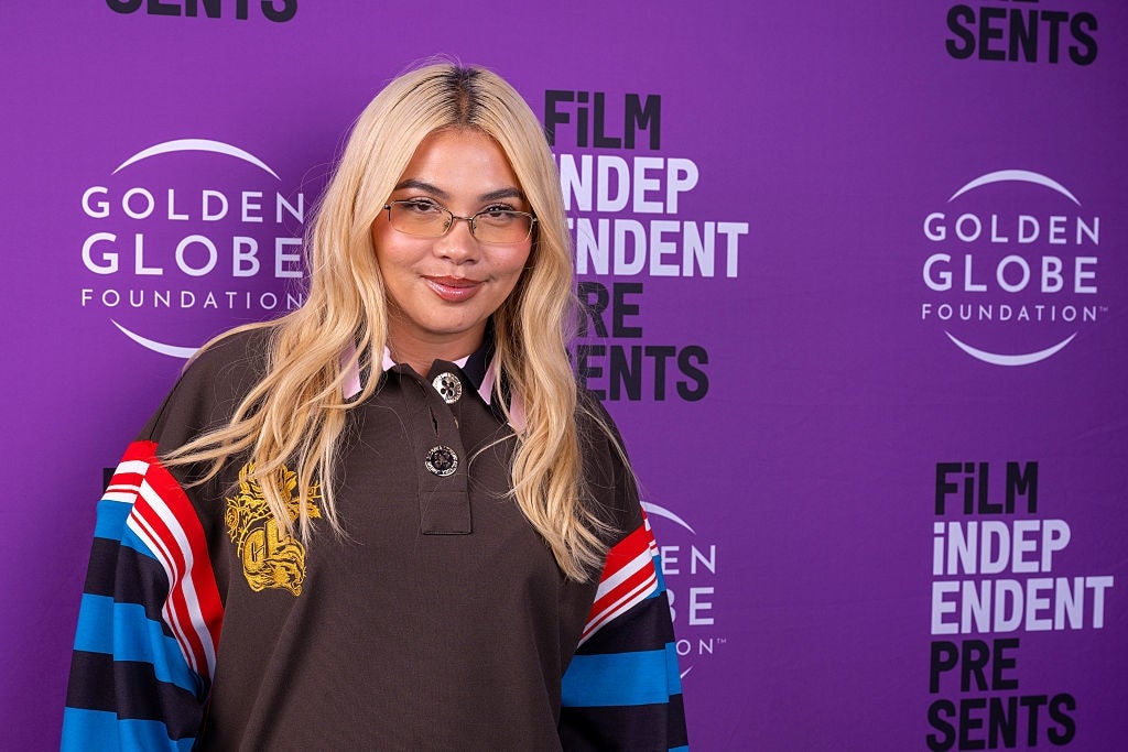 Person posing connected  a measurement   and repetition  with "Golden Globe Foundation" and "Film Independent Presents" logos, successful  casual attire with colorful sleeve accents