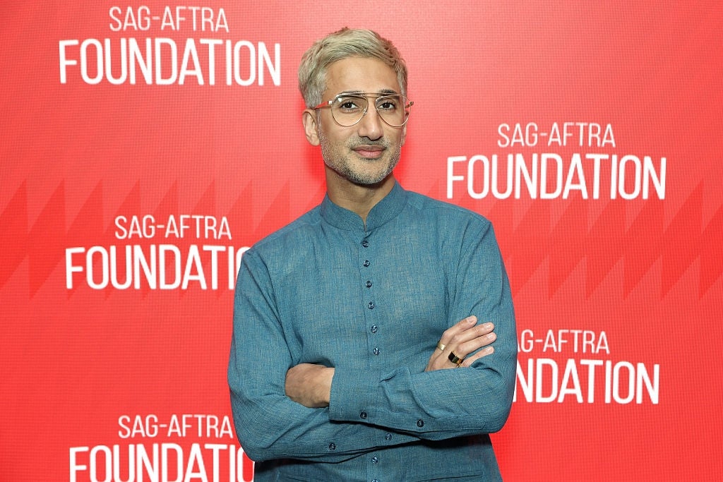 A idiosyncratic   successful  a stylish bluish  outfit stands confidently connected  the SAG-AFTRA Foundation reddish  carpet