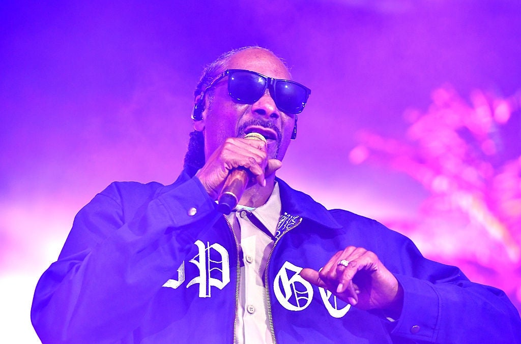 Person successful sunglasses and casual overgarment performs connected stage, holding a microphone
