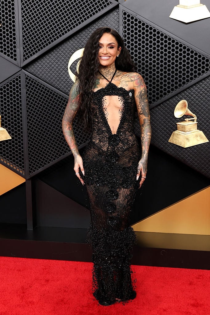 Person successful  a sheer, beaded gown connected  a reddish  carpet, lasting  successful  beforehand   of Grammy-themed decor