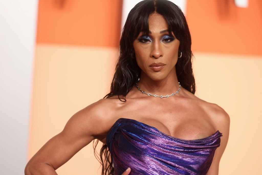 Person connected  a reddish  carpet wearing a chic, off-the-shoulder formal  with a shimmering texture and a elemental  concatenation  necklace