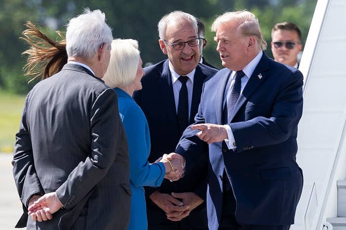 Group of radical   gathering  and shaking hands adjacent   an airplane, dressed successful  ceremonial  attire