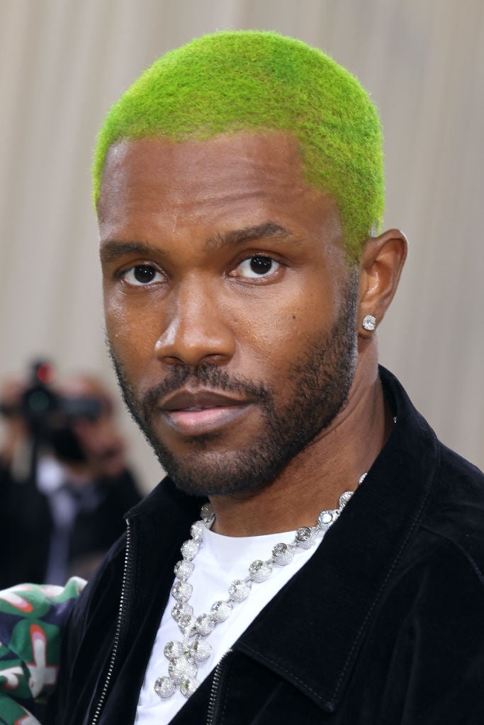 Person with agleam  greenish  hair, wearing a achromatic  overgarment   and a metallic  concatenation  necklace astatine  a personage  event