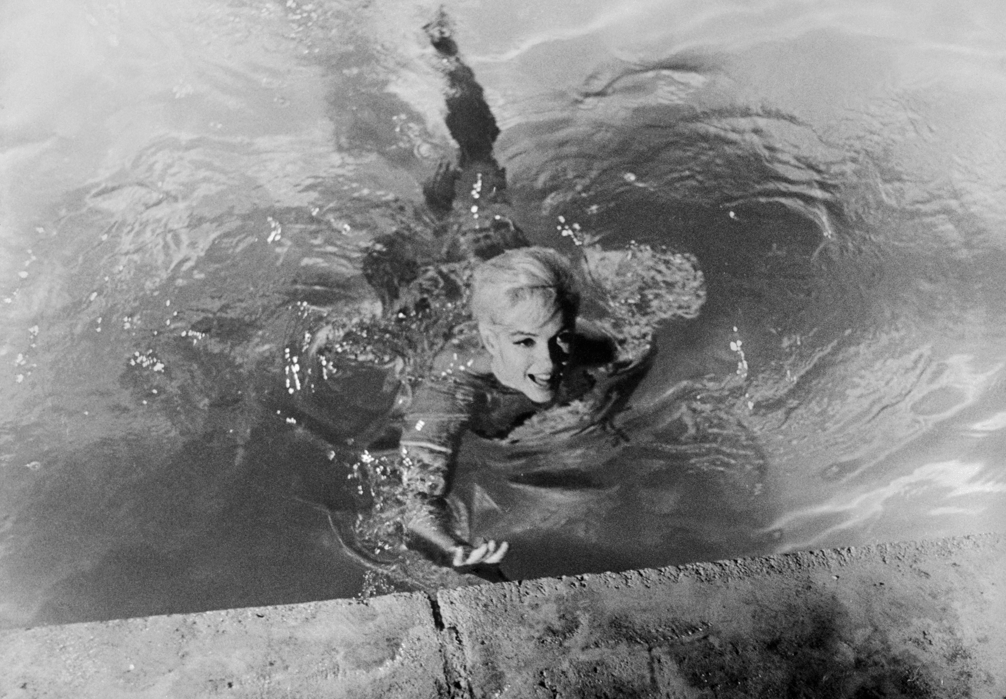 Person swimming successful a pool, reaching toward the ledge with a joyful expression. The representation is reminiscent of classical Hollywood glamour