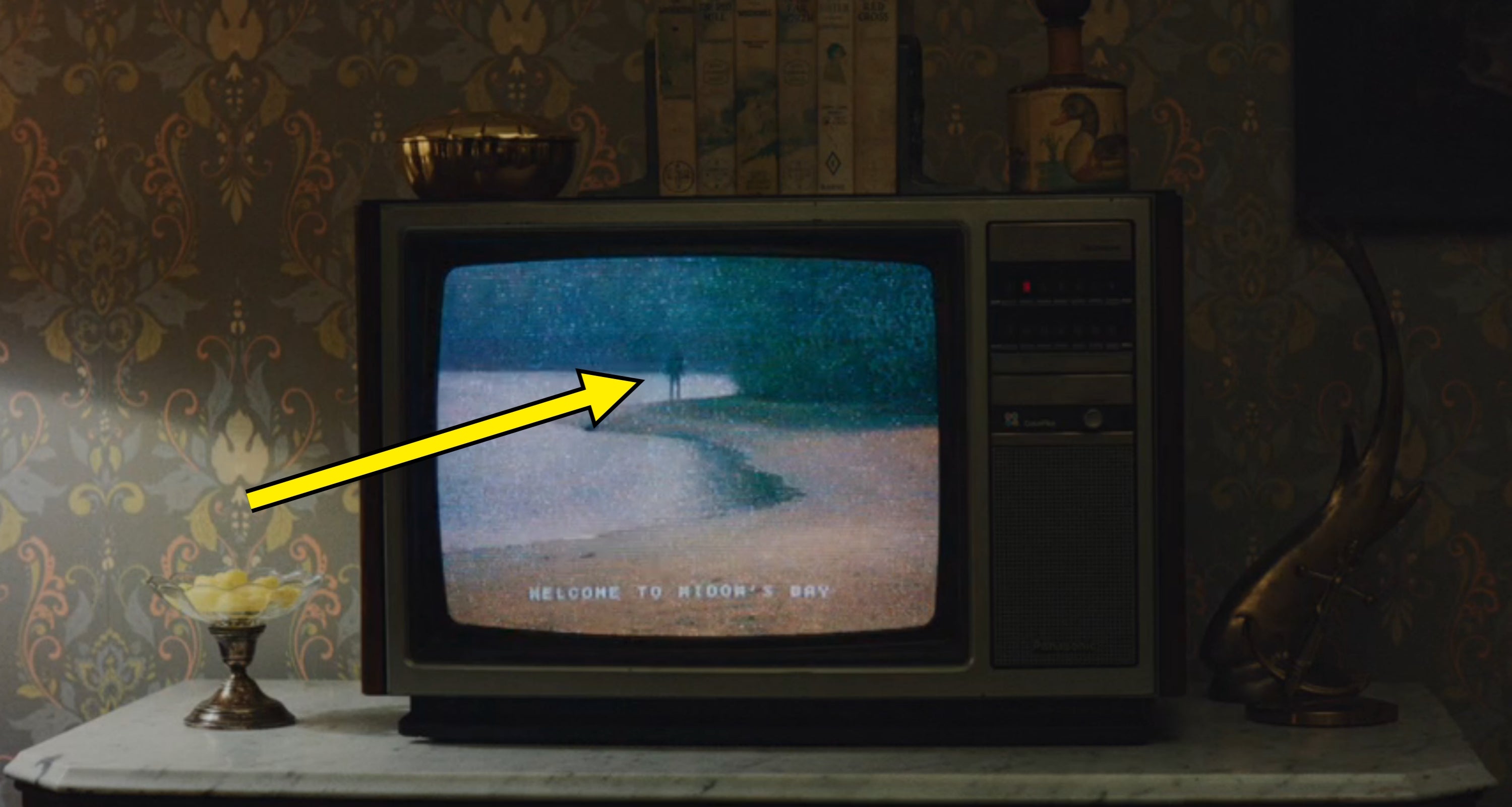 A vintage tv  displays a country   of a idiosyncratic   walking by a stream  with the substance   "Welcome to Aroyd's Bay" disposable   connected  the screen