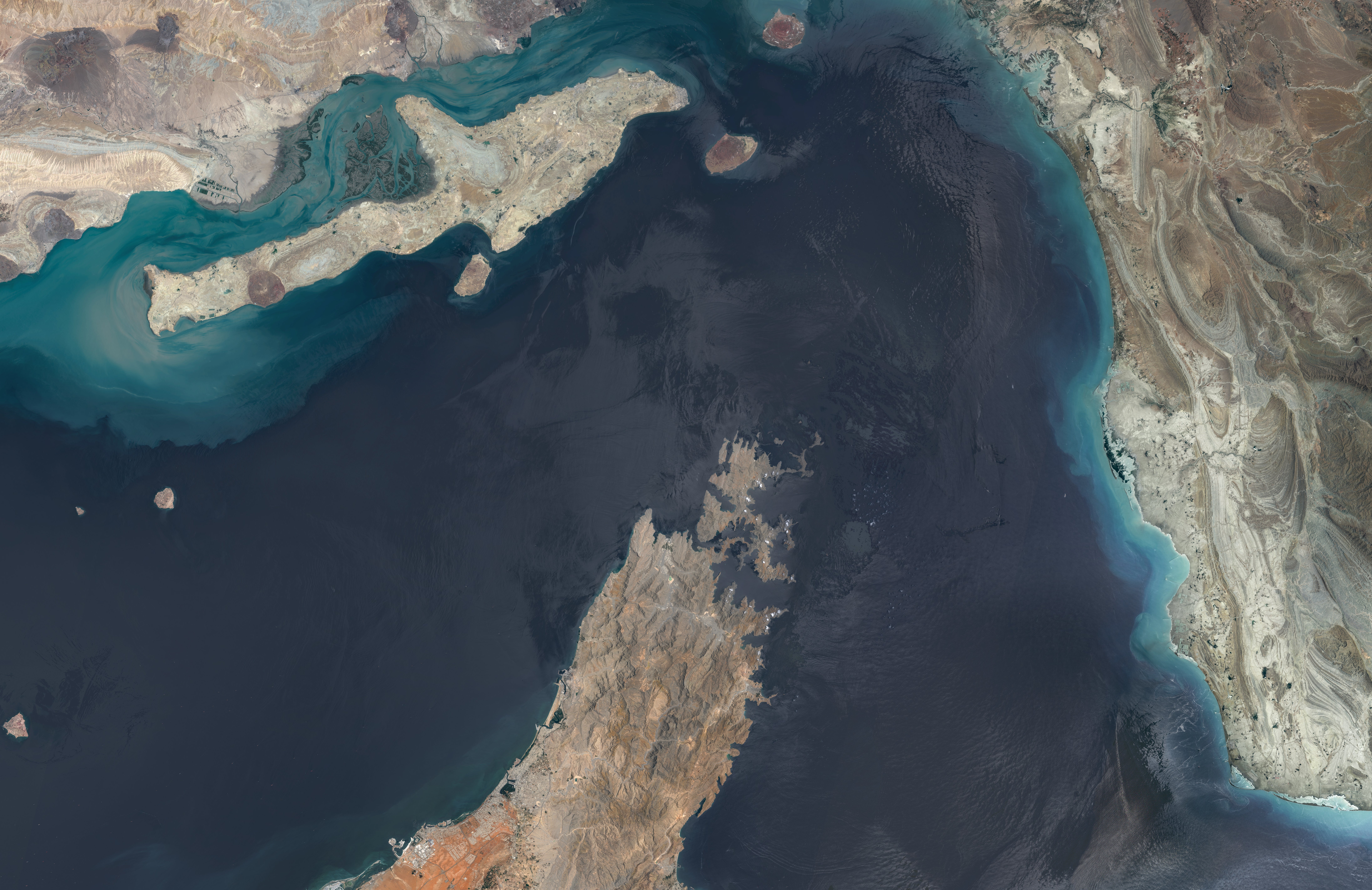 Satellite presumption of a coastal portion with landmasses and h2o bodies, showing assorted terrains and geographical formations