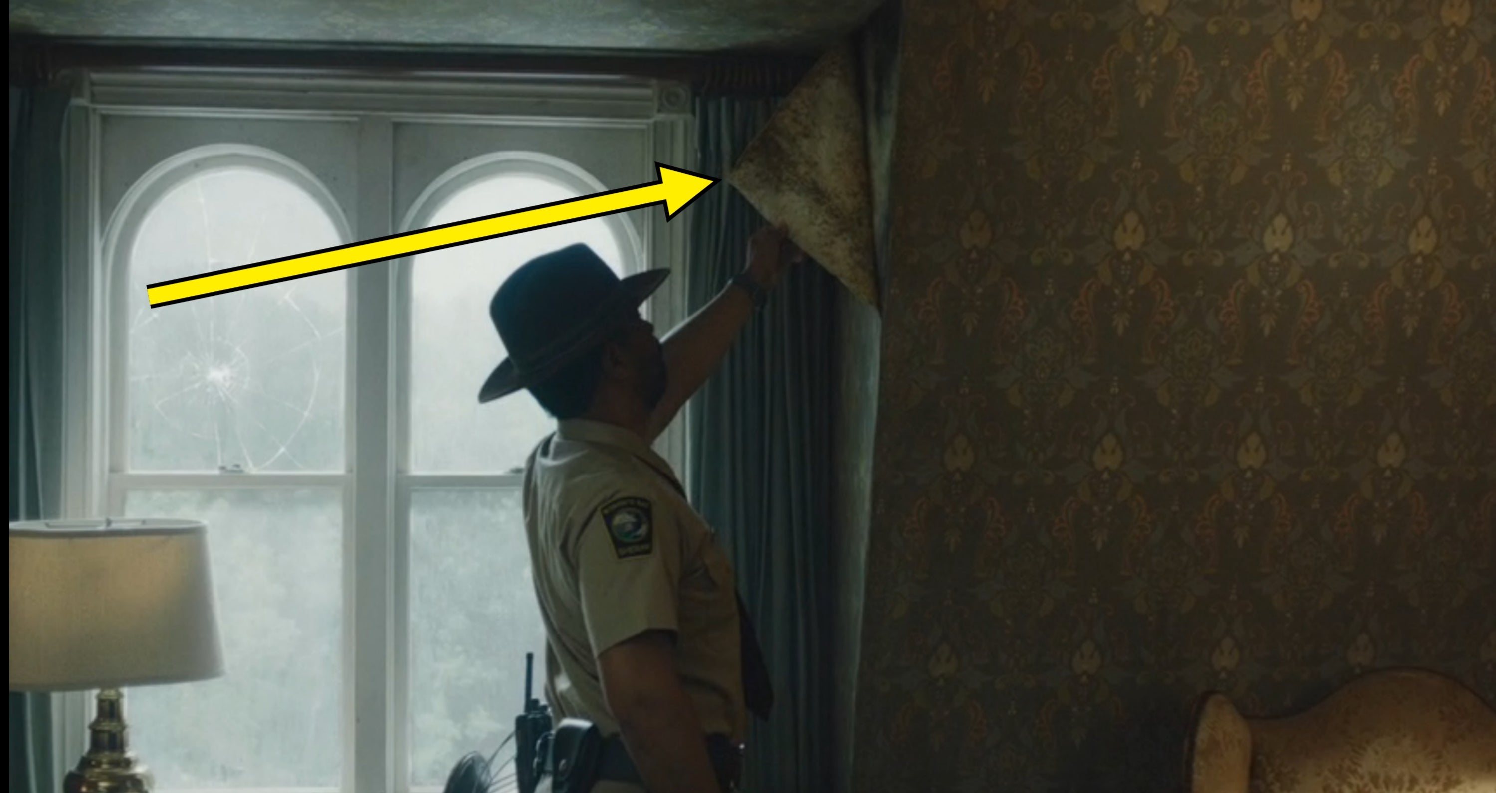 Person successful  a sheriff's azygous   peeling wallpaper successful  a dimly lit country   with a lamp and a window