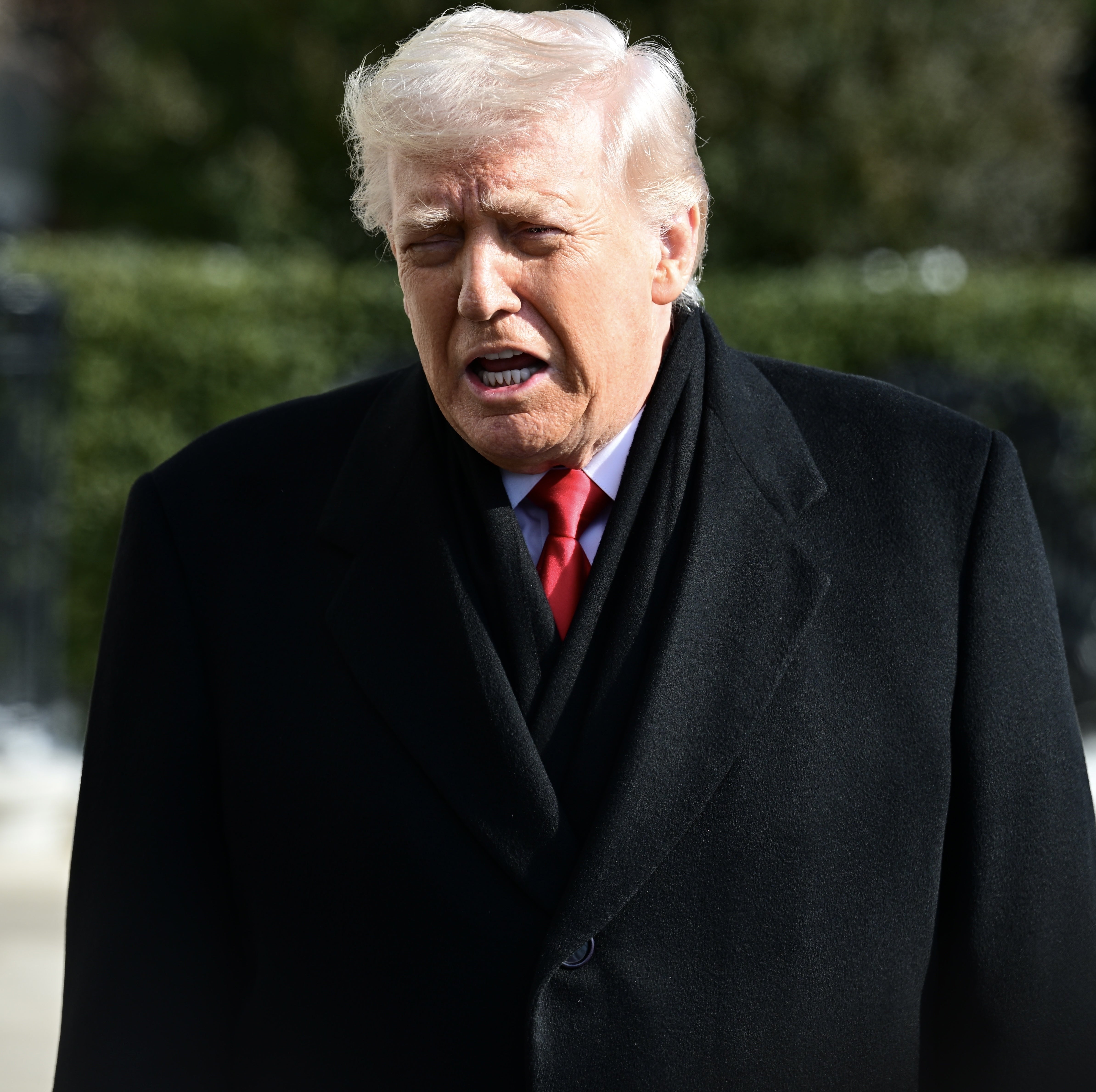 A idiosyncratic successful a ceremonial achromatic overgarment and reddish necktie speaking outdoors
