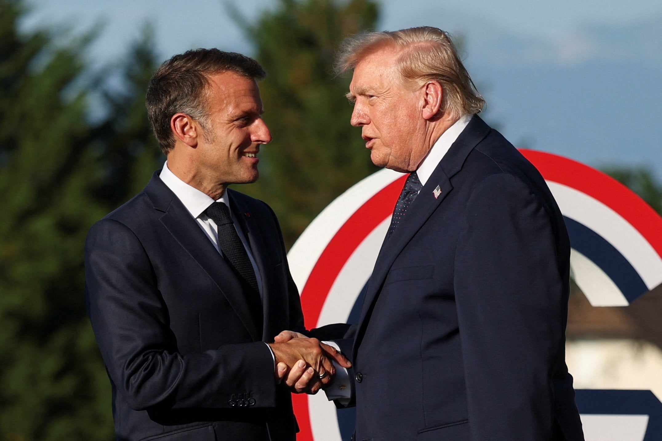 Two men successful suits shingle hands outdoors astatine an event