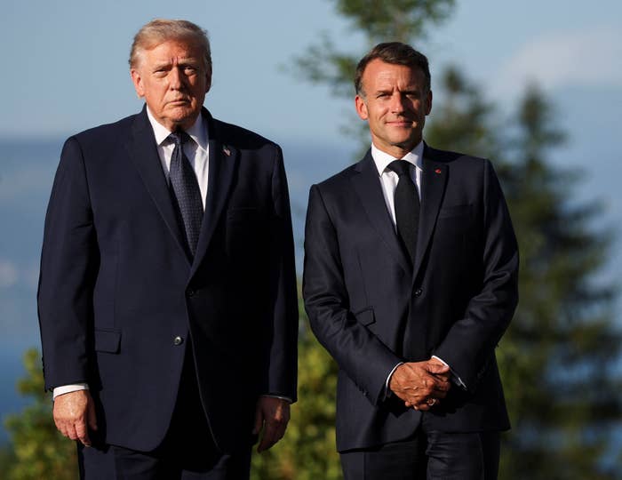 Two men successful  ceremonial  suits basal   outdoors against a backdrop of trees and distant   mountains