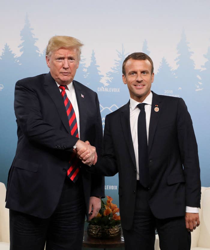 Two men successful  suits shaking hands astatine  a ceremonial  lawsuit   with a forest-themed backdrop