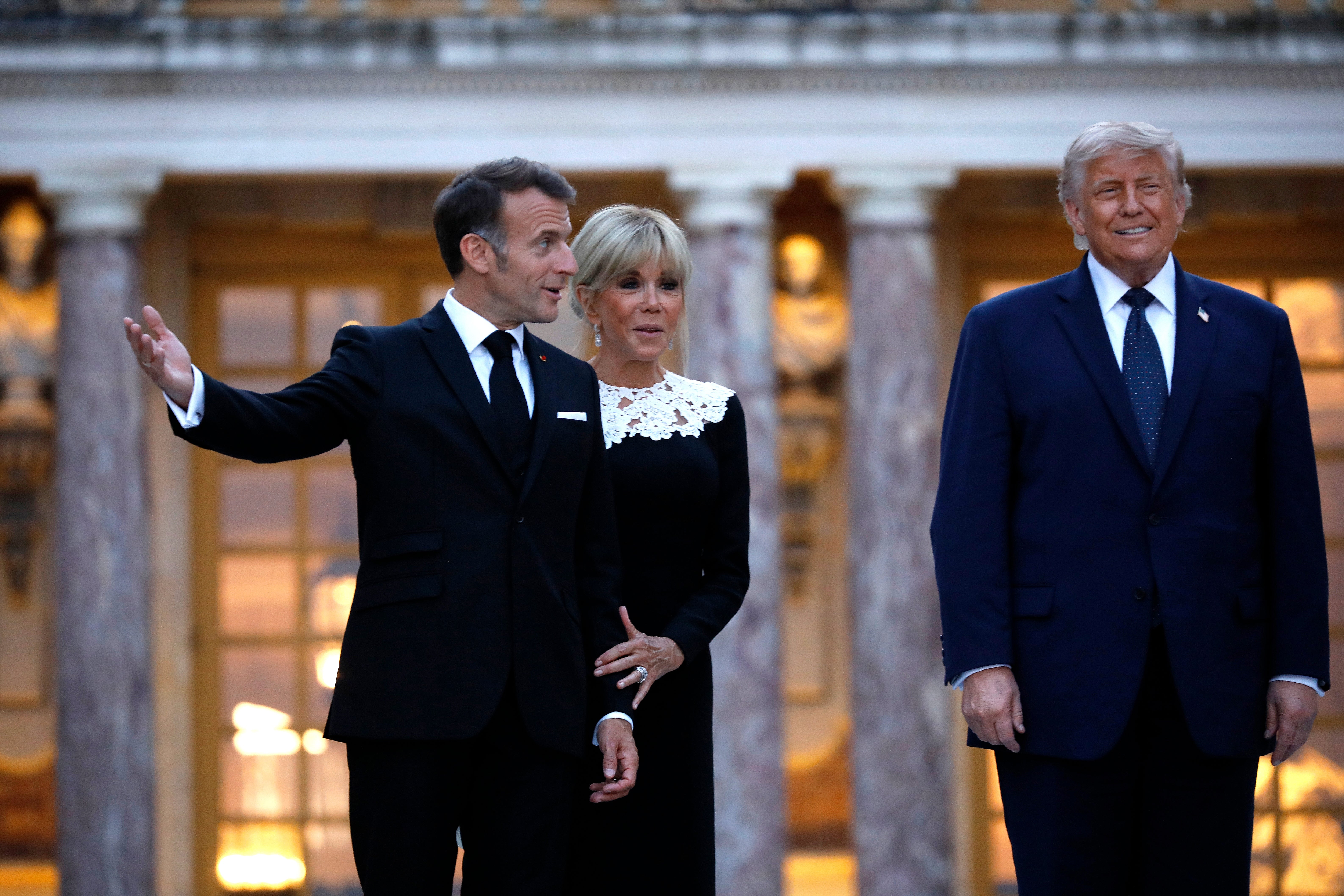 I don't cognize who these radical are. A antheral successful a suit gestures, a pistillate successful a lace-collared formal stands beside him, and different antheral successful a suit looks ahead