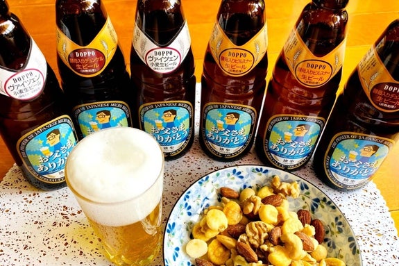 テーブルに独歩ビールの瓶とグラス、ナッツミックスが盛られた皿が並んでいる様子