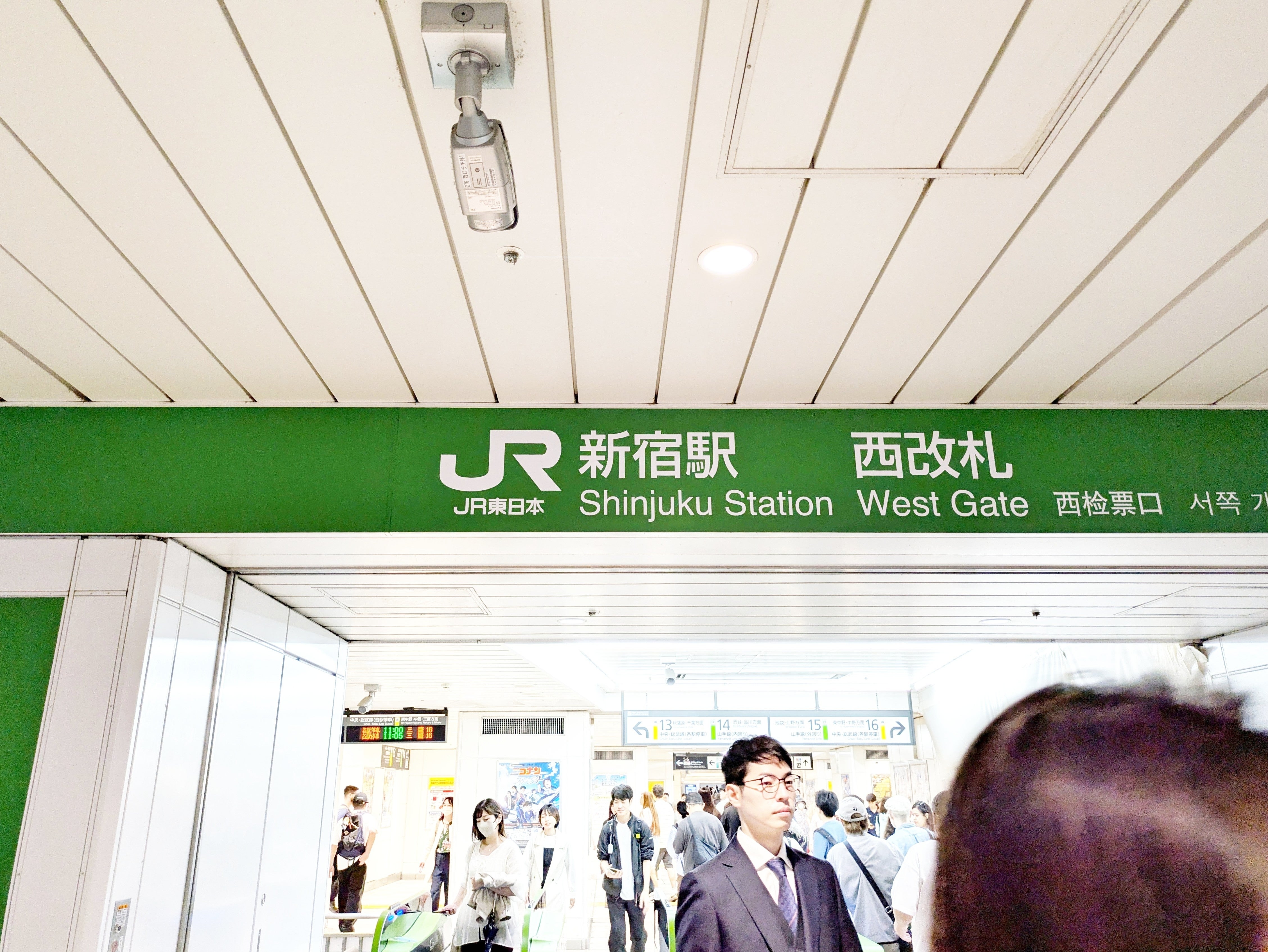 新宿駅西改札の入口。多くの人々が行き交っている。