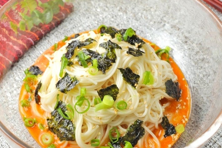 ガラスボウルに盛られたそうめん、ネギと海苔がトッピングされている。