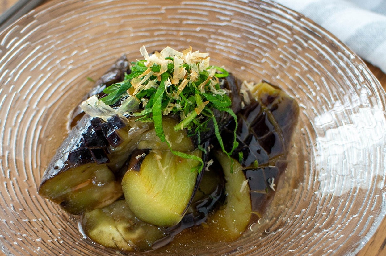ガラス皿に盛られた揚げナスの料理。上に青じそと削り節がトッピングされています。