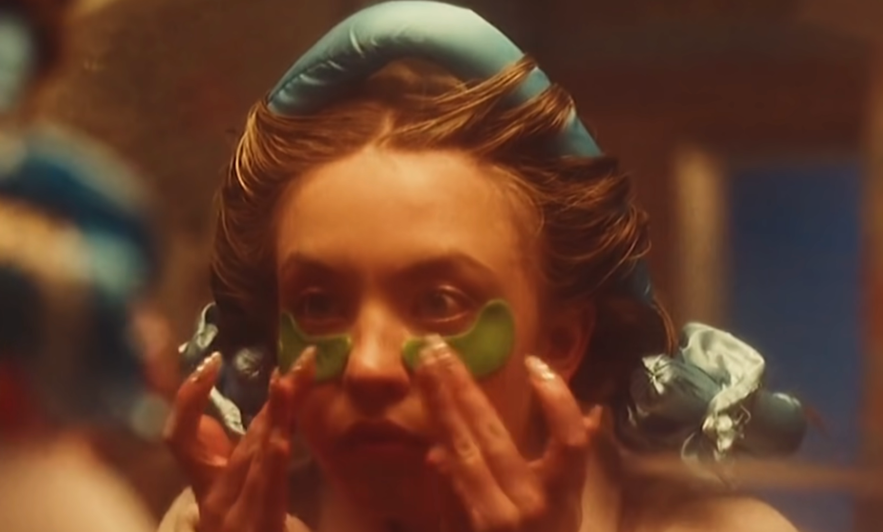 Sydney Sweeney wearing hairsbreadth curlers, applying greenish under-eye patches successful "Euphoria"