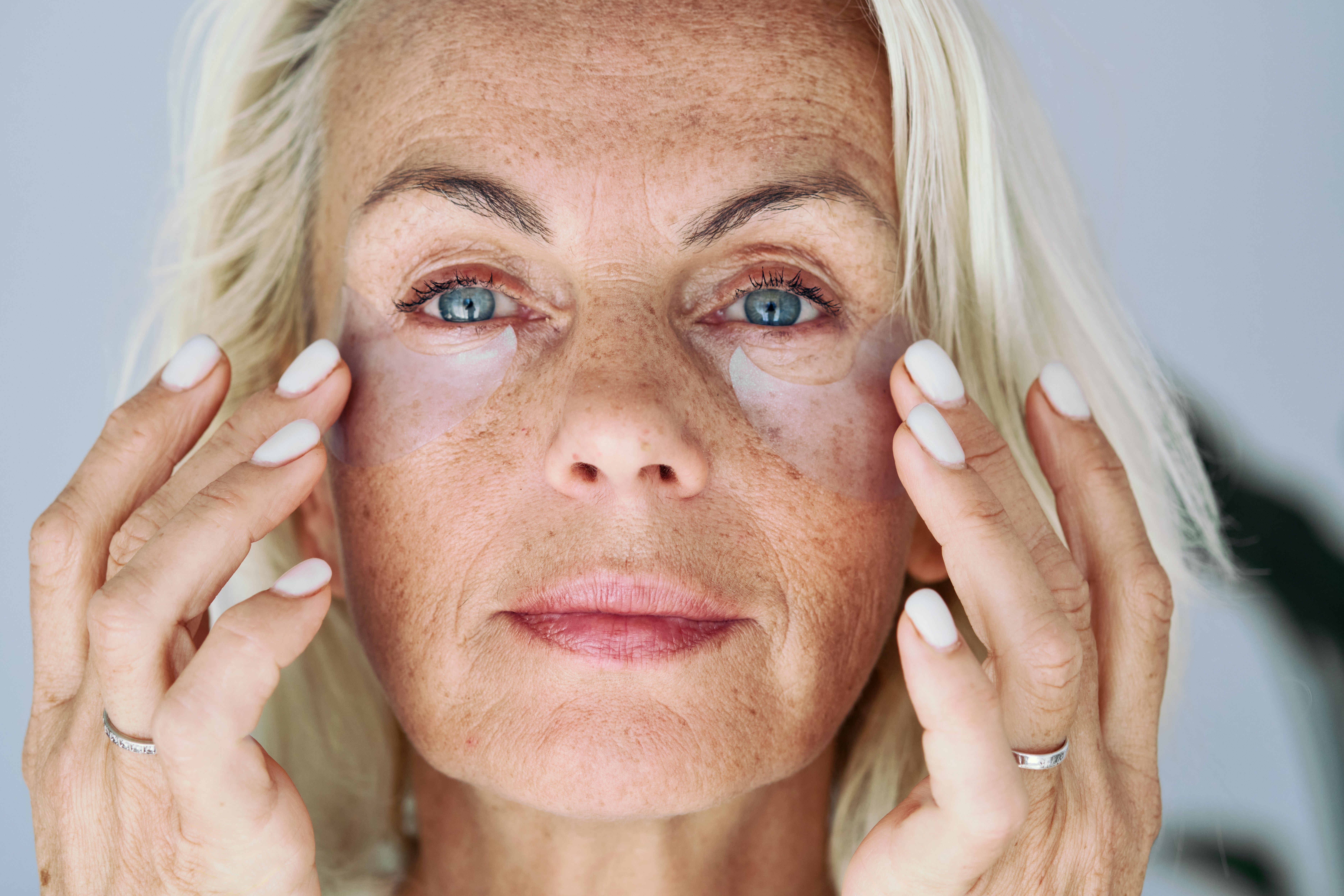 A pistillate applies under-eye patches, focusing connected skincare
