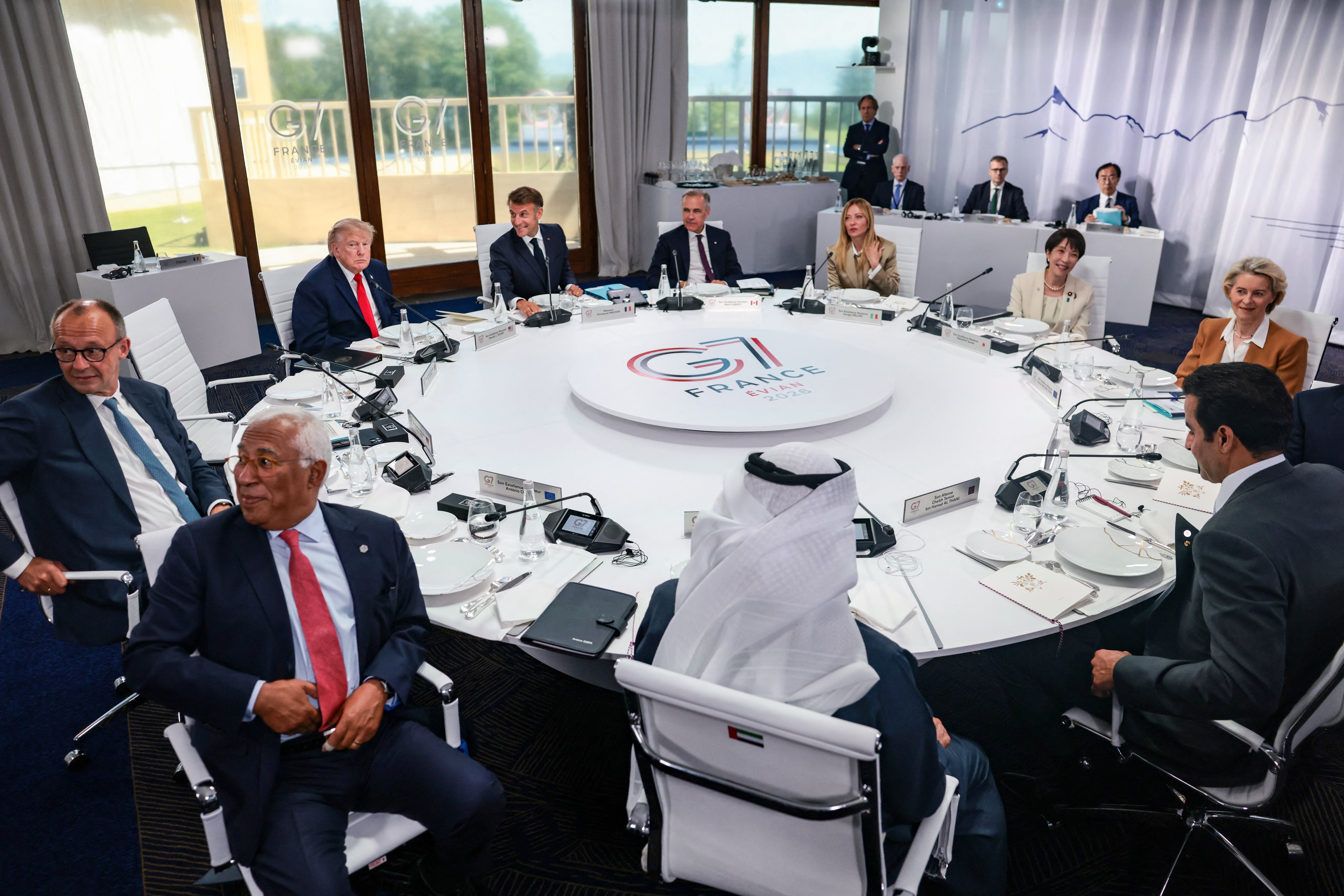 Leaders astir a circular array astatine the G7 summit, engaged successful discussion. Large windows successful the inheritance supply a presumption of the outside