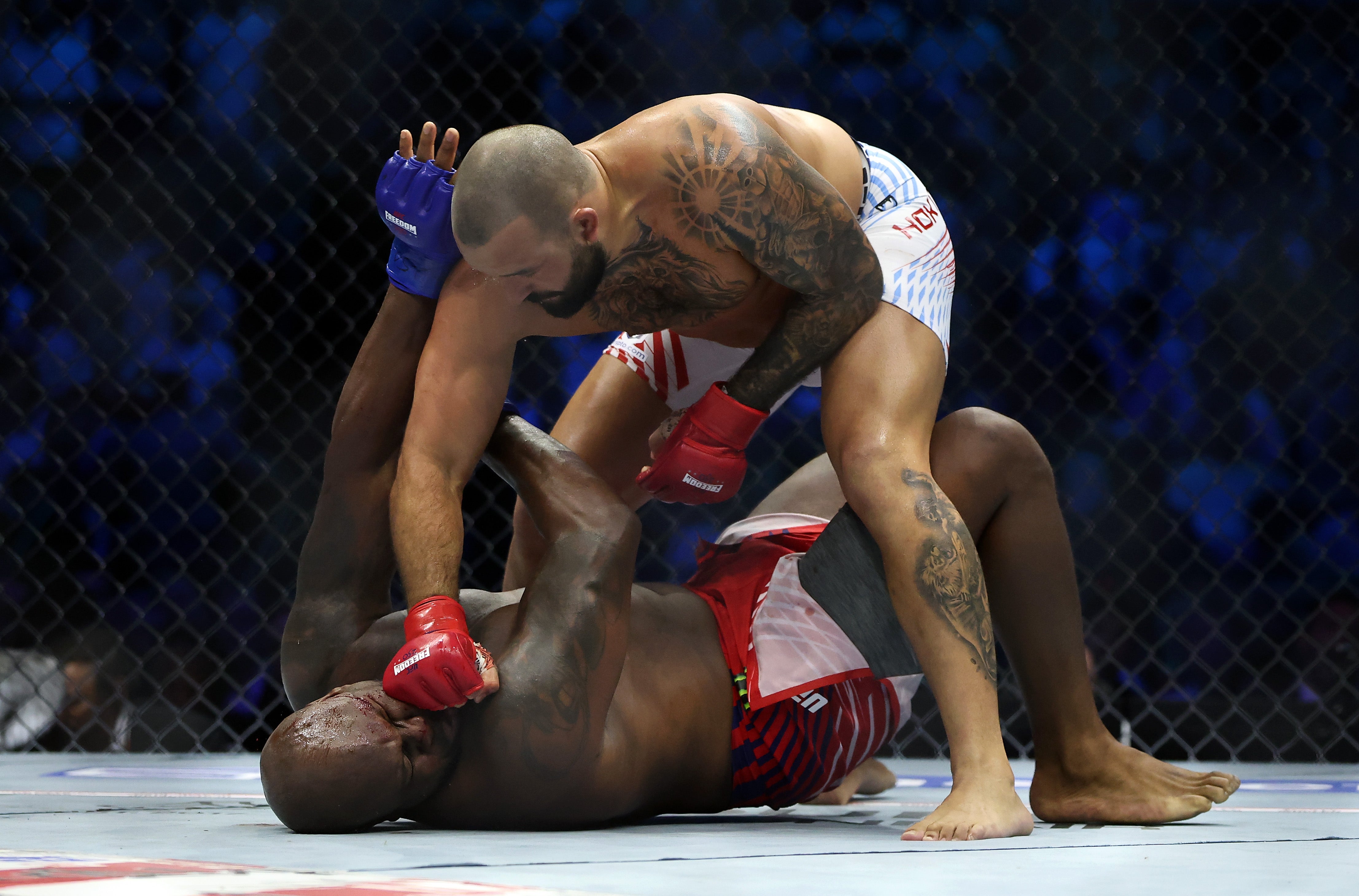 Two MMA fighters successful a cage; 1 is pinning the different to the crushed and preparing to strike