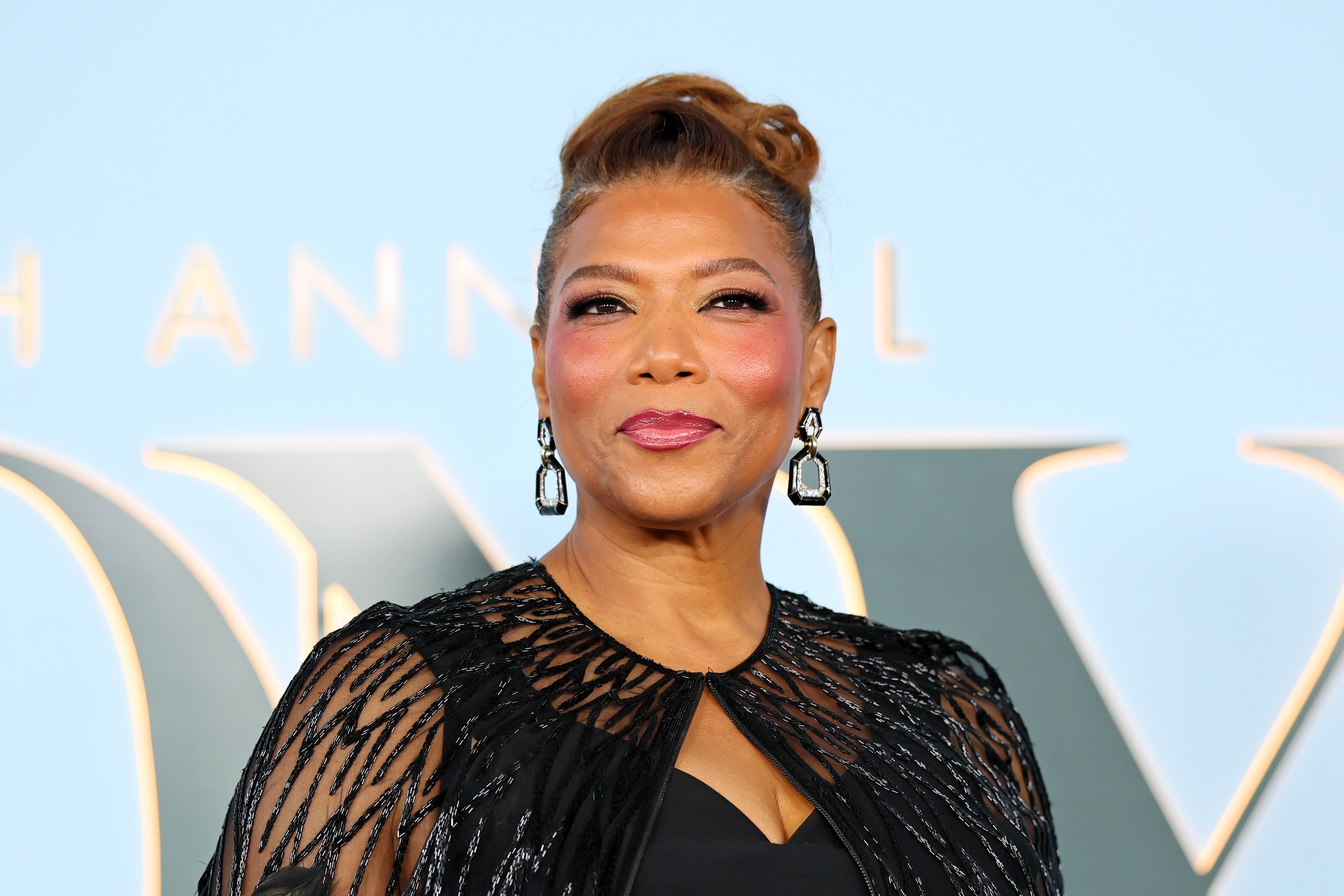 Person successful elegant attire, wearing a achromatic lace gown and connection earrings, smiling astatine an event